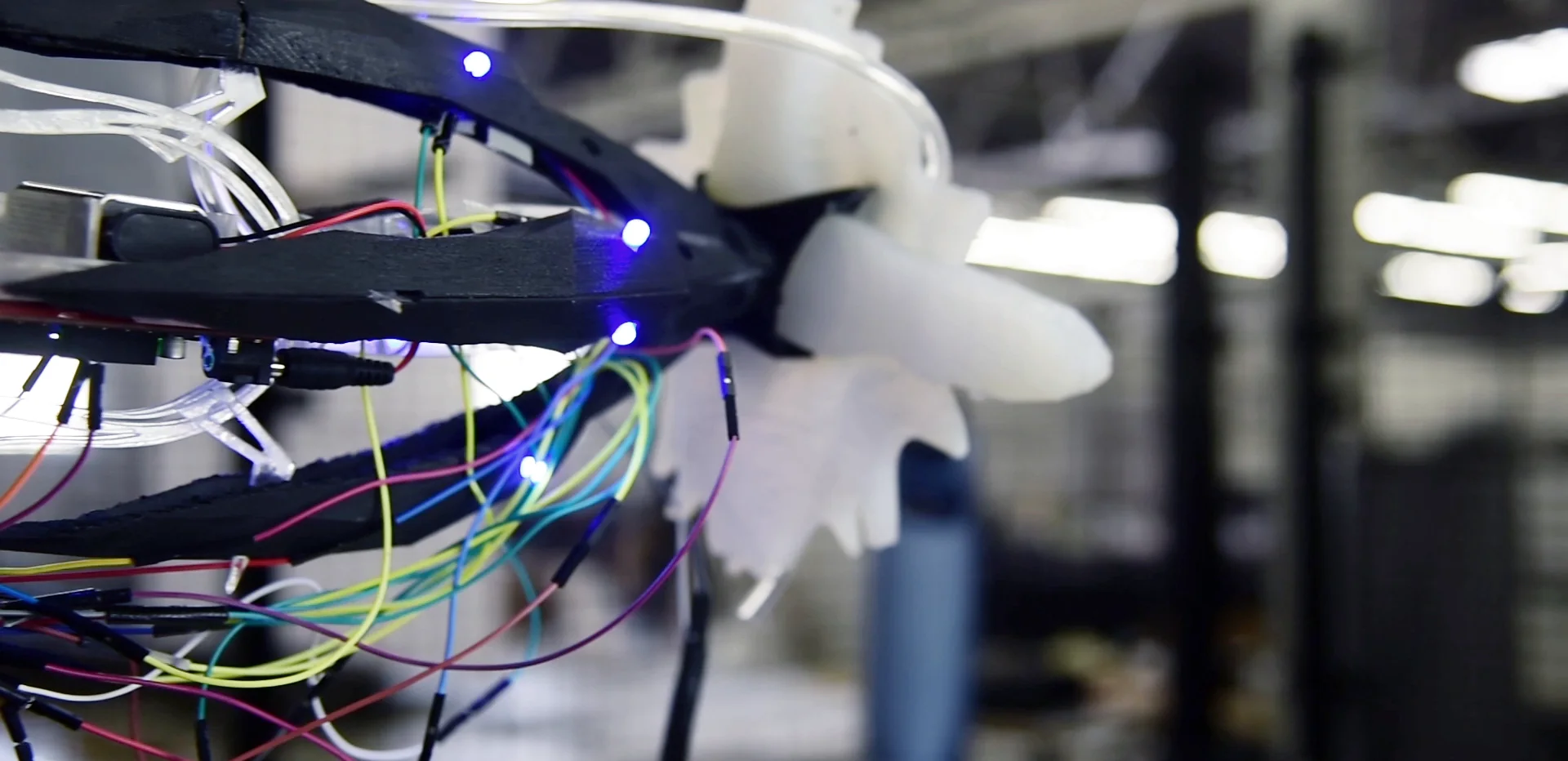 A KUKA robot arm with a 3D-printed shell, wiring, and a white silicone gripper